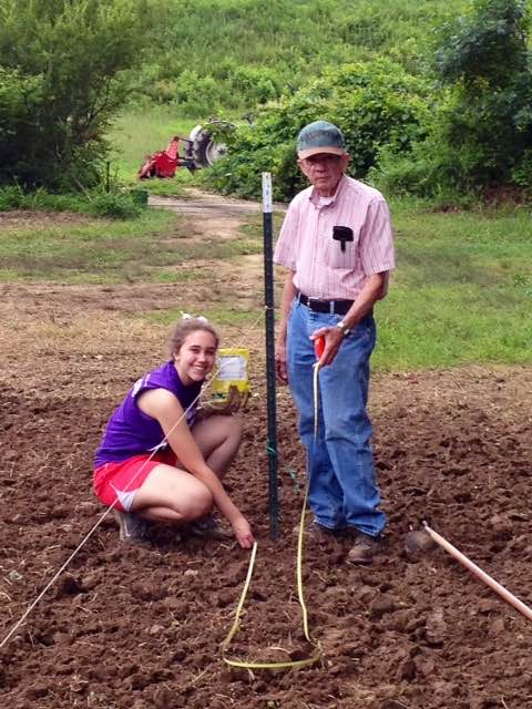 Breann Pritchett with her grandfather Marving Pritchett planting pumpkins
			   at the pumpkin patch